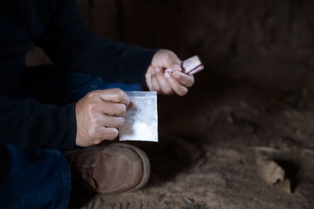 Close-up of a person holding a bag of methamphetamine, highlighting the need for meth addiction treatment in Reseda CA.