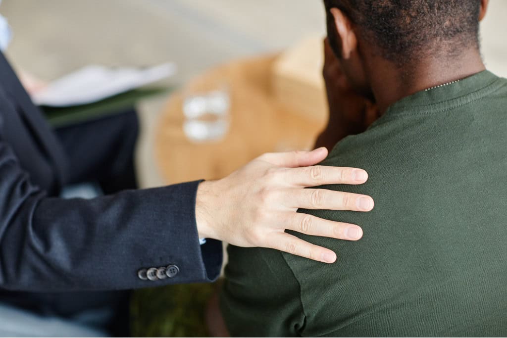 A supportive hand on a patient's shoulder representing PTSD treatment in Reseda CA, focusing on compassionate care and mental health recovery.