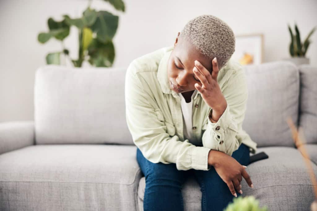 A woman, visibly distressed, covers her face with her hand, displaying the emotional weight of past trauma. Trauma Therapy in Reseda, CA offers compassionate, professional care to help individuals overcome traumatic experiences.