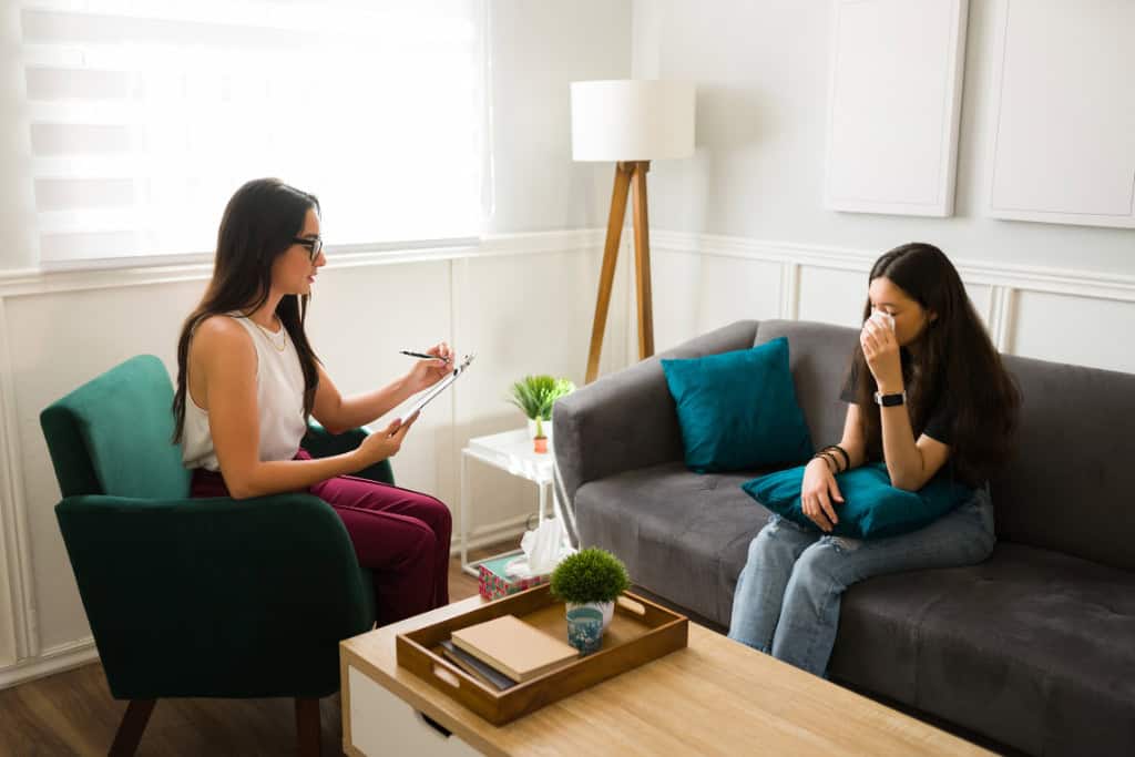 A therapist offers a comforting touch on a patient’s shoulder, symbolizing support and empathy. Trauma Therapy in Reseda, CA provides individuals a safe space to address their emotional challenges and find healing.