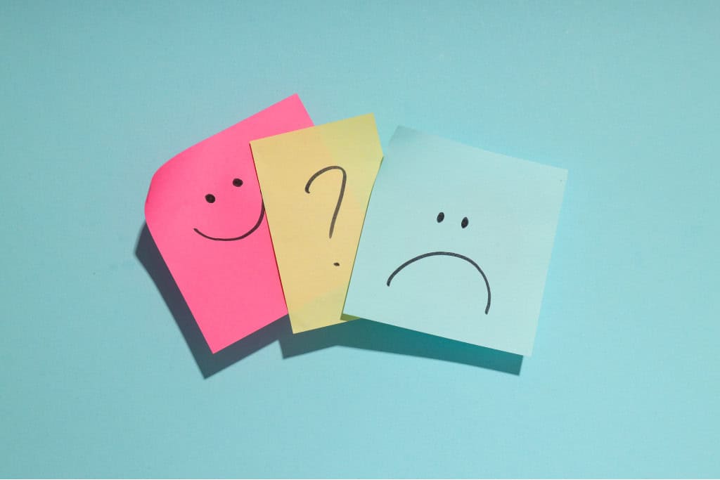Colorful sticky notes display different mood icons—smiling, neutral, and sad—symbolizing the fluctuating emotional states common in bipolar disorder. This visual is a reminder of the treatment support available for bipolar management in Reseda, CA.