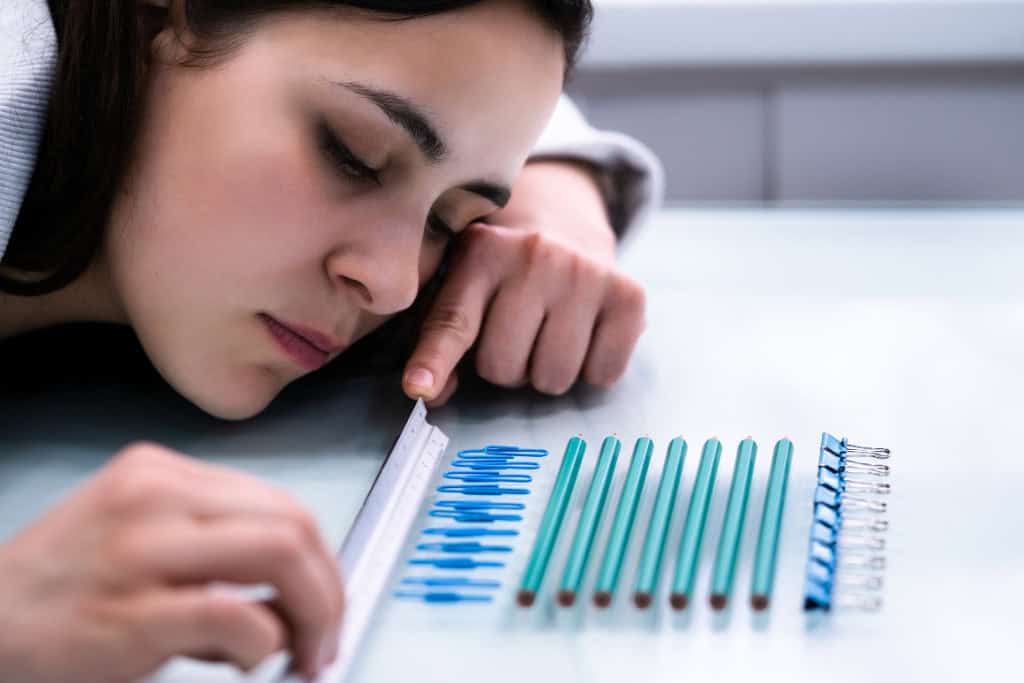 A close-up of a woman using a ruler to align pencils, symbolizing the obsessive tendencies that can be addressed through OCD treatment in Reseda, CA.