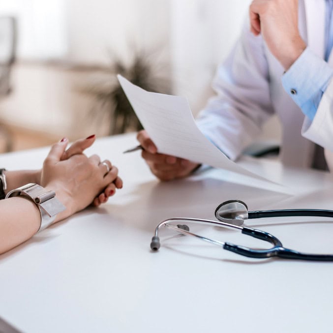 A doctor discusses treatment options with a patient, emphasizing the medical support available for addiction treatment in Reseda CA, with a stethoscope on the desk symbolizing professional healthcare.